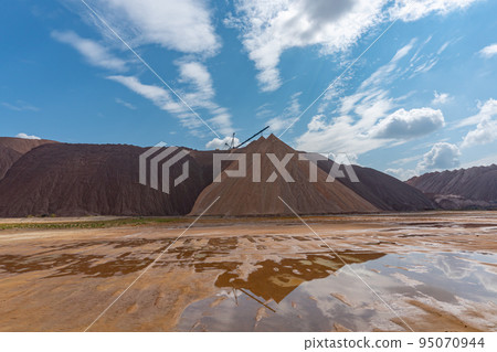 Mining industry close up. Telestacker handles the ore closeup for potash waste heaps, extraction of salt and potash fertilizers in a quarry and processing of ore 95070944