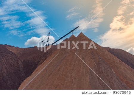 Mining industry close up. Telestacker handles the ore closeup for potash waste heaps, extraction of salt and potash fertilizers in a quarry and processing of ore 95070946