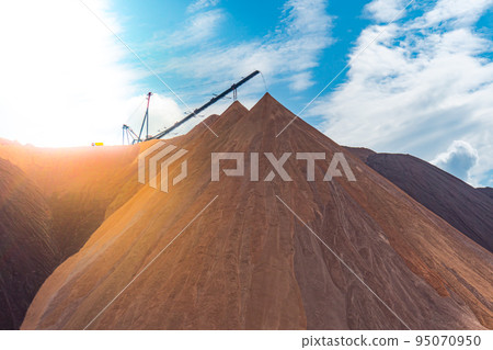 Mining industry close up. Telestacker handles the ore closeup for potash waste heaps, extraction of salt and potash fertilizers in a quarry and processing of ore Mining industry close up. Telestacker handles the ore closeup for potash waste heaps, extraction of salt and potash fertilizers in a quarry and processing of ore 95070950