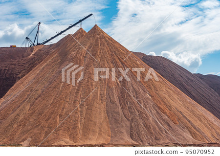 Mining industry close up. Telestacker handles the ore closeup for potash waste heaps, extraction of salt and potash fertilizers in a quarry and processing of ore Mining industry close up. Telestacker handles the ore closeup for potash waste heaps, extraction of salt and potash fertilizers in a quarry and processing of ore 95070952