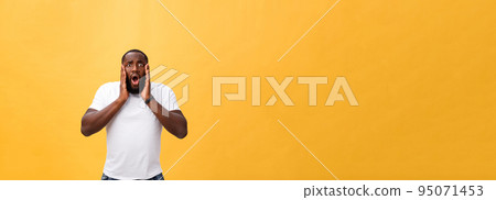 Amazed young African American hipster wearing white t-shirt holding hands in surprised gesture, keeping mouth wide open, looking shocked Amazed young African American hipster wearing white t-shirt holding hands in surprised gesture, keeping mouth wide open, looking shocked 95071453