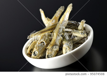 在黑色背景下拍攝了一小盤煮熟的干沙丁魚。 95074508