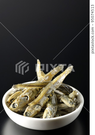 在黑色背景下拍攝了一小盤煮熟的干沙丁魚。 在黑色背景下拍攝了一小盤煮熟的干沙丁魚。 95074513