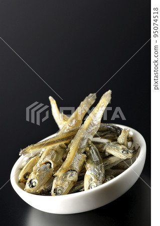 在黑色背景下拍攝了一小盤煮熟的干沙丁魚。 在黑色背景下拍攝了一小盤煮熟的干沙丁魚。 95074518