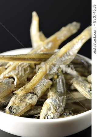 在黑色背景下拍攝了一小盤煮熟的干沙丁魚。 在黑色背景下拍攝了一小盤煮熟的干沙丁魚。 95074519