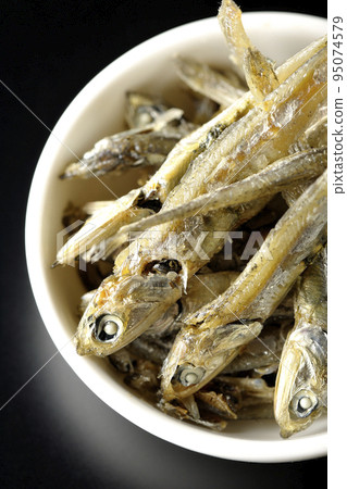 黑色背景小盤子上的干沙丁魚鳥瞰圖 95074579