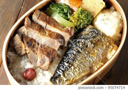 A bird's-eye view of a grilled fish bento box containing pork, potato salad, omelet, etc. 95074714