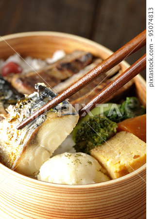 Eat salt-grilled mackerel in a grilled fish bento box containing pork, potato salad, and omelet. Eat salt-grilled mackerel in a grilled fish bento box containing pork, potato salad, and omelet. 95074813