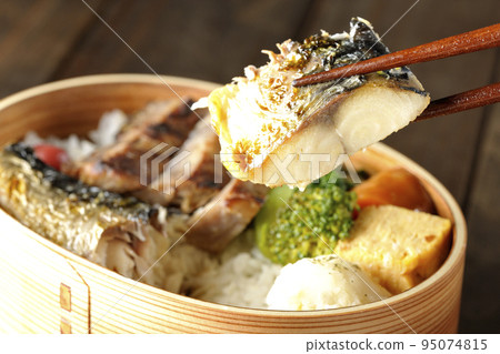 Eat salt-grilled mackerel in a grilled fish bento box containing pork, potato salad, and omelet. Eat salt-grilled mackerel in a grilled fish bento box containing pork, potato salad, and omelet. 95074815