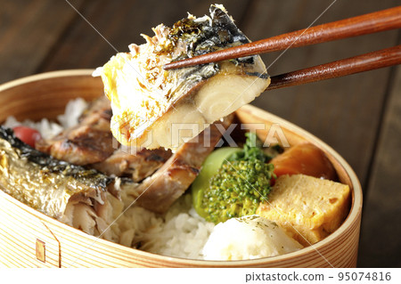 在裝有豬肉、土豆沙拉和煎蛋捲的烤魚便當盒中吃鹽烤鯖魚。 95074816