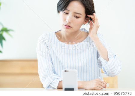 Woman receiving online medical treatment 95075773