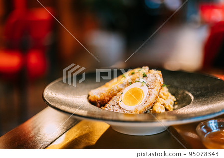 Traditional "Scotch egg". "Skirly" is fried oatmeal with onions and spices, a classic garnish of Scotland. Honey mustard sauce. Traditional dish of Scotland 95078343
