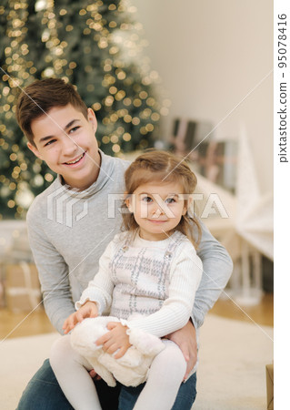 Happy young boy with his niece play in front of fir tree. Christmas mood Happy young boy with his niece play in front of fir tree. Christmas mood 95078416