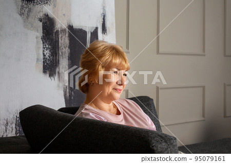Elderly woman sitting on couch. Profile portrait. Elderly woman sitting on couch. Profile portrait. 95079161