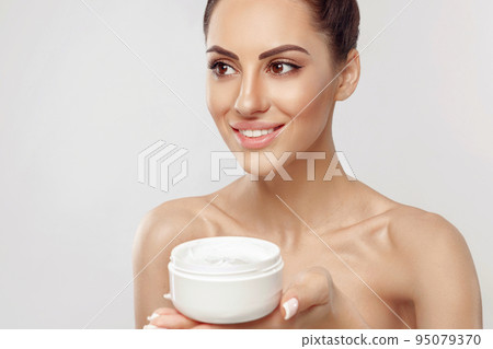Young Woman Holding Cosmetic Moisturizing Cream. Soft Skin And Naked Shoulders, Model With Light Nude Make-Up, Portrait Of Girl Face With Clean Healthy Skin. 95079370