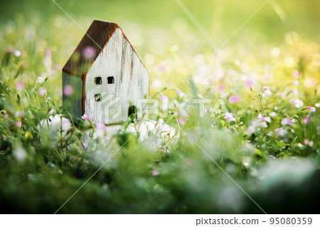 Living in a Harmony Lifestyle Concept. Wooden House Model on Green Grass. Close to Nature 95080359