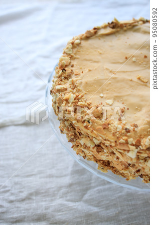 napoleon cake, round whole with caramel cream on a white background. copy space napoleon cake, round whole with caramel cream on a white background. copy space 95080592