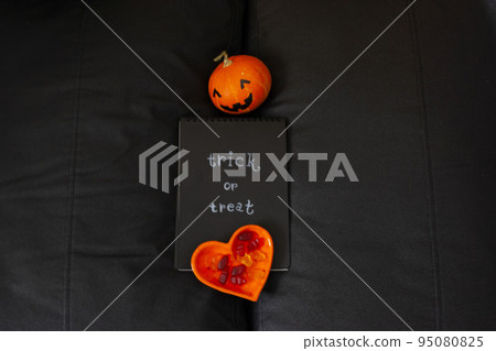 Pumpkin for Halloween notepad with inscription and orange coffee pot place for text black background trick or treat 95080825