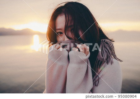 Photo of a woman with a beautiful sunrise 95080904