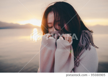 Photo of a woman with a beautiful sunrise 95080905