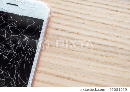 broken glass of mobile phone screen on wooden background 95081939