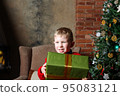 Happy caucasian boy holding present in hand. 95083121