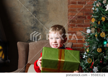 Happy caucasian boy holding present in hand. Happy caucasian boy holding present in hand. 95083121