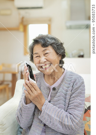 Senior woman making a phone call at home 95083733