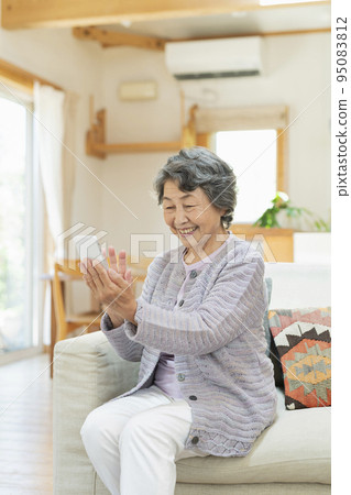 Senior woman making a video call with her grandson at home 95083812