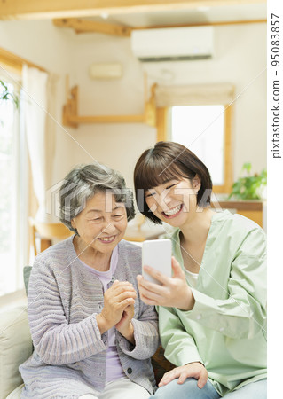 Senior woman teaching grandchild how to use smartphone Senior woman teaching grandchild how to use smartphone 95083857