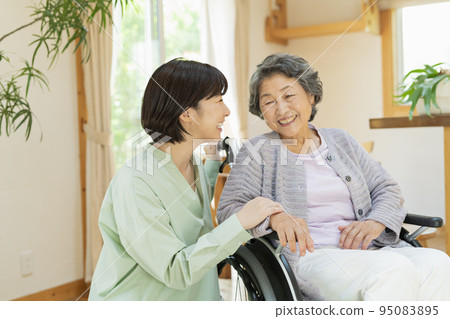Senior woman in a wheelchair with her grandson Senior woman in a wheelchair with her grandson 95083895