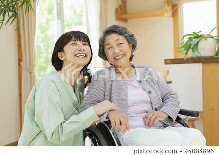Senior woman in a wheelchair with her grandson Senior woman in a wheelchair with her grandson 95083896