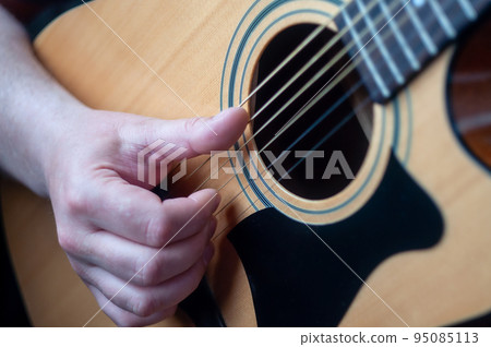 The musician plays the acoustic guitar. The musician plays the acoustic guitar. 95085113