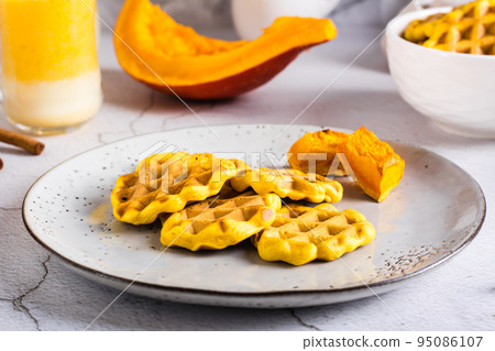 Pumpkin waffles on a plate on the table. Homemade baking. Pumpkin waffles on a plate on the table. Homemade baking. 95086107