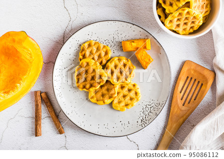 Pumpkin waffles on a plate on the table. Homemade baking. Top view Pumpkin waffles on a plate on the table. Homemade baking. Top view 95086112