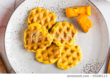 Pumpkin waffles on a plate on the table. Homemade baking. Top view. Closeup Pumpkin waffles on a plate on the table. Homemade baking. Top view. Closeup 95086113