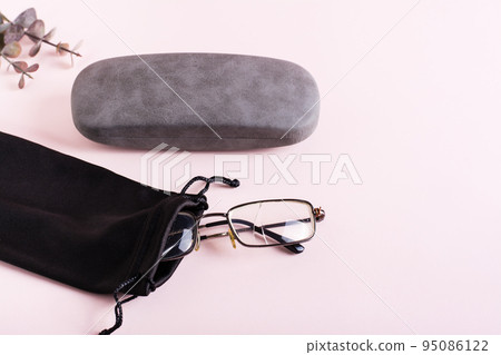 Broken glasses in a soft case and a hard case next to it. The concept of careful storage of optics Broken glasses in a soft case and a hard case next to it. The concept of careful storage of optics 95086122