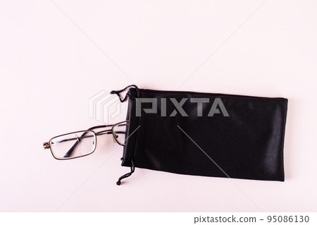 Glasses with a broken lens in a soft case. Incorrect storage of optics. Top view. Glasses with a broken lens in a soft case. Incorrect storage of optics. Top view. 95086130