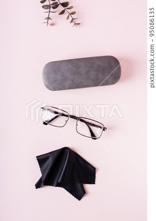 Case, glasses  and cleaning cloth on a pink background. Storage and care. Top and vertical view 95086135