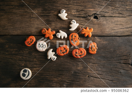 Halloween gingerbread cookies on wooden planks. Halloween pumpkin, ghosts and gingerman. Top view. Halloween gingerbread cookies on wooden planks. Halloween pumpkin, ghosts and gingerman. Top view. 95086362