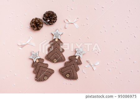 Christmas handmade. Knitted fir-trees and pine cones on a pastel background. Handicraft and leisure. Copy space Christmas handmade. Knitted fir-trees and pine cones on a pastel background. Handicraft and leisure. Copy space 95086975