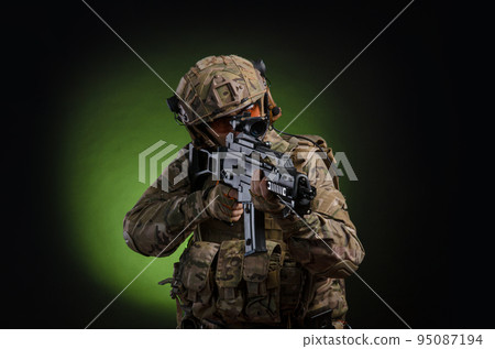 a male soldier in military clothes with a weapon on a dark background a male soldier in military clothes with a weapon on a dark background 95087194