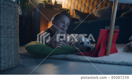 Young girl watching movies with dog Young girl watching movies with dog 95087239
