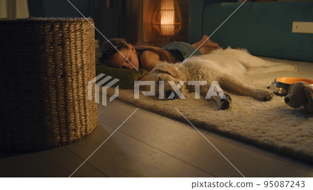 Young girl sleeping with dog on mild carpet Young girl sleeping with dog on mild carpet 95087243