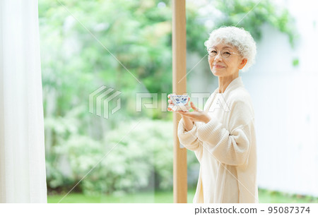 Silver-haired woman drinking tea Silver-haired woman drinking tea 95087374