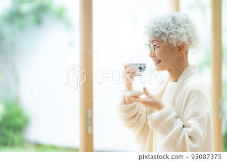 Silver-haired woman drinking tea Silver-haired woman drinking tea 95087375