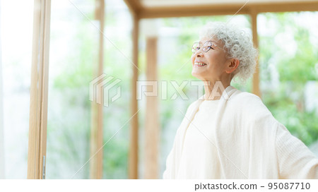Senior woman taking a deep breath in the living room Senior woman taking a deep breath in the living room 95087710