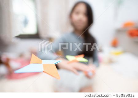 Girl playing with origami shuriken Girl playing with origami shuriken 95089032