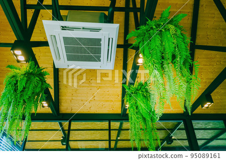 Ceiling air conditioning system, open-air, circulating air throughout the modern style, popular installed in coffee shops. Ceiling mounted cassette type air conditioner in the cafes. 95089161