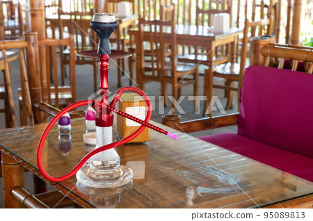 Shisha hookah with red hot coals stands on a table 95089813